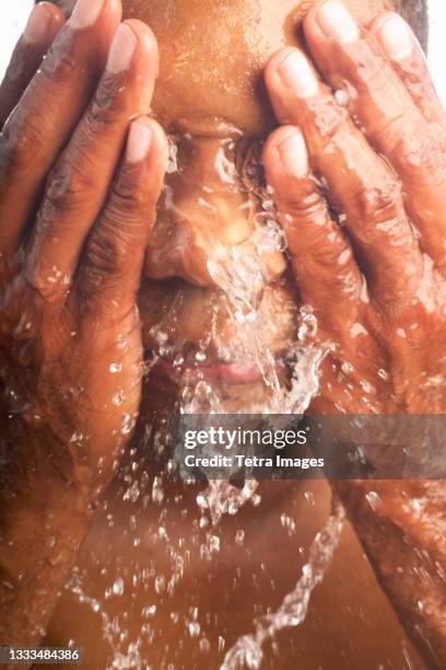 close-up of man washing face - gesichtsreinigung stock-fotos und bilder