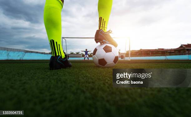 soccer player playing soccer ball on sports field - aftrappen stockfoto's en -beelden
