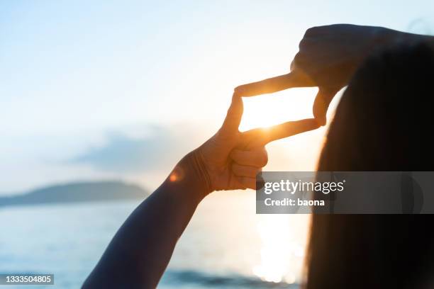 sun in the hand frame - finger frame stock pictures, royalty-free photos & images