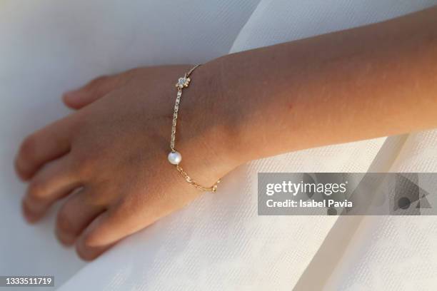 detail of girl bracelet in first communion day - bracelet fotografías e imágenes de stock