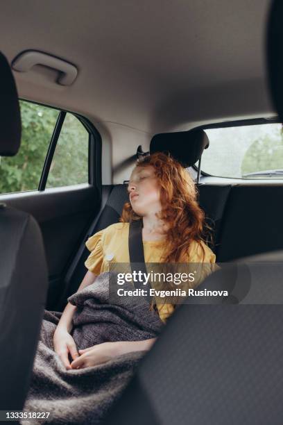 red-haired girl fell asleep in the car - sleeping in car foto e immagini stock