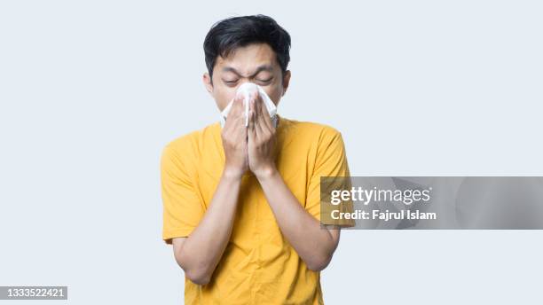 asian man sneezing - asiatischer mann freigestellt stock-fotos und bilder