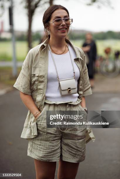 Maria Astor wearing light beige shorts and shirt styling with white top and mini bag on a neck outside Gestuz during Copenhagen fashion week SS22 on...