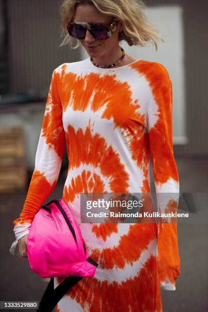 Pernille Rosenkilde wearing bright white and orange maxi dress, sneakers and pink bag outside Gestuz during Copenhagen fashion week SS22 on August...