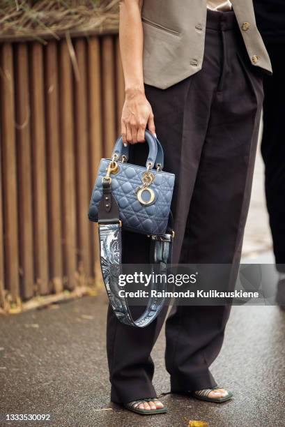 Pornwika Spiecker wearing black pants, light top, a vest, a hat and blue Dior bag outside Gestuz during Copenhagen fashion week SS22 on August 10,...