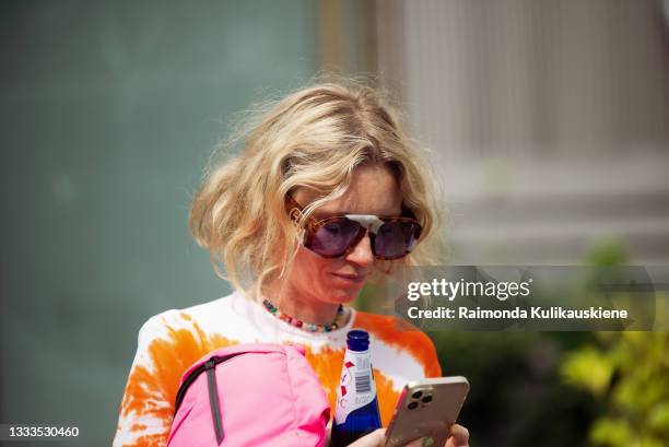 Pernille Rosenkilde wearing bright white and orange maxi dress, sneakers and pink bag outside Gestuz during Copenhagen fashion week SS22 on August...