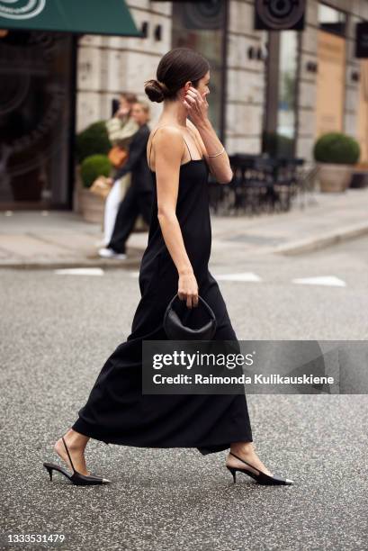 Guest wearing black slip dress outside The Garment during Copenhagen fashion week SS22 on August 10, 2020 in Copenhagen, Denmark.
