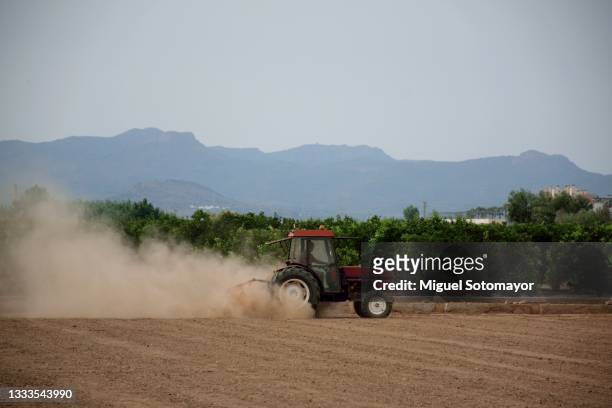 tractor tilling the land in a dry area - tractor ploughing field bildbanksfoton och bilder