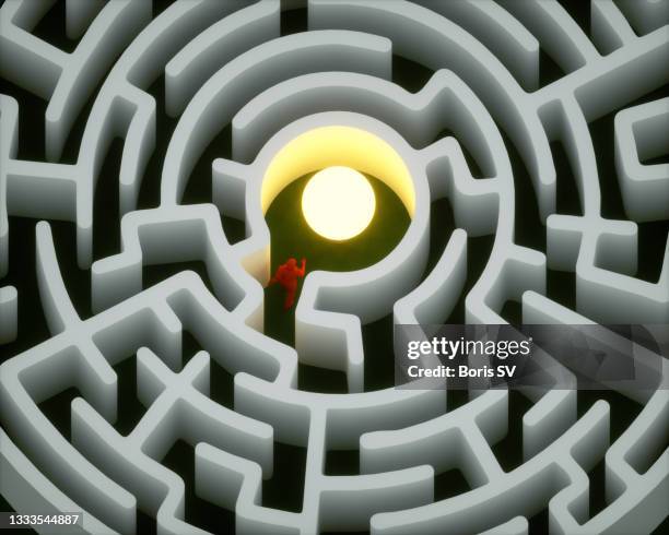 man finding the light bulb in labyrinth - mystery stock-fotos und bilder