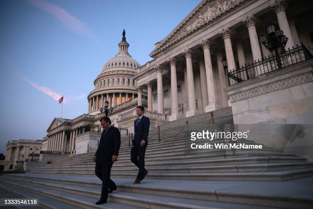 Sen. Ted Cruz and special assistant Gray Harker depart the U.S. Capitol at dawn after an overnight session of the U.S. Senate on August 11, 2021 in...