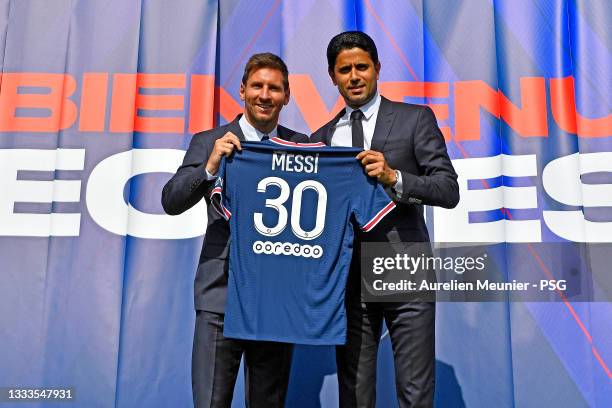 Lionel Messi poses with his jersey next to President Nasser Al Khelaifi after the press conference of Paris Saint-Germain at Parc des Princes on...