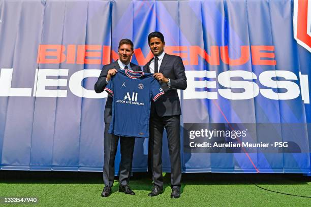 Lionel Messi poses with his jersey next to President Nasser Al Khelaifi after the press conference of Paris Saint-Germain at Parc des Princes on...