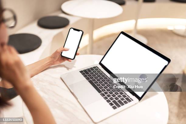 a young woman responds to work messages with her mobile phone in a public area - smartphone mockup stock-fotos und bilder