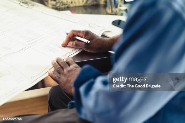 architect looking at blueprint at desk in office - creative desk ストックフォトと画像