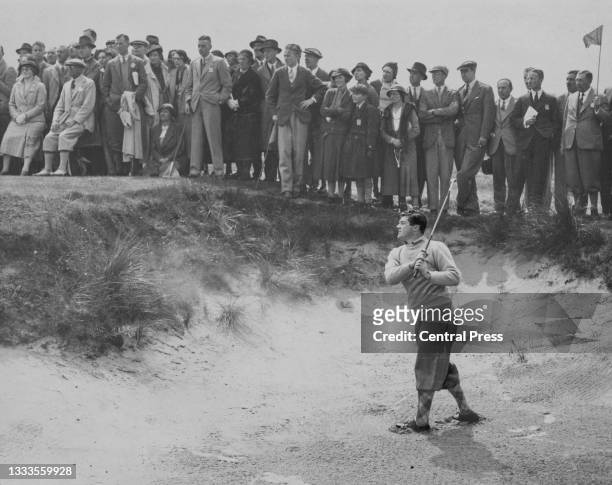 Crowd of spectators look on as Lawson Little of the United States plays a shot from the sand bunker on his way to winning The Amateur Championship...