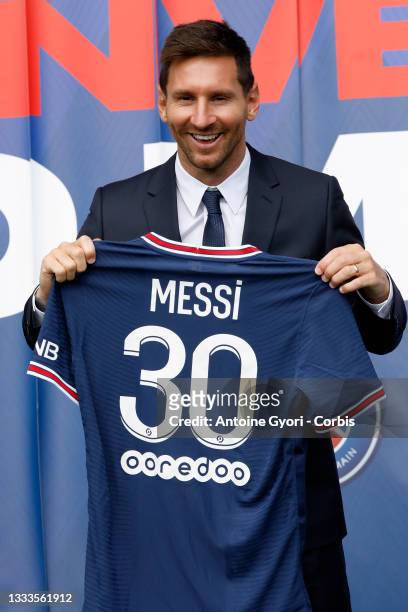 Lionel Messi poses with his jersey after a press conference where he was unveiled as a Paris Saint-Germain player at Parc des Princes on August 11,...