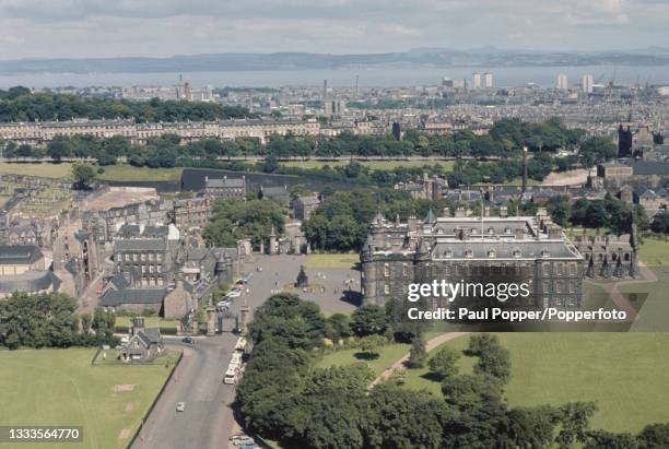 Aerial view from Salisbury Crags of the Palace of Holyroodhouse and Holyrood Abbey with the city of Edinburgh and Firth of Forth in the background,...