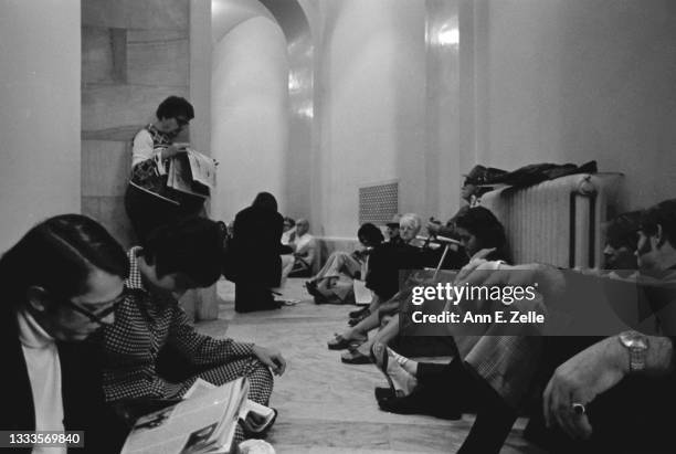 View of members of the public, some reading, as they wait in a hall of the Russell Senate Office Building, Washington DC, October 3, 1973. They were...