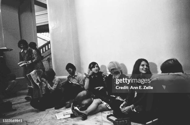 View of members of the public, some reading, as they wait in a hall of the Russell Senate Office Building, Washington DC, October 3, 1973. They were...