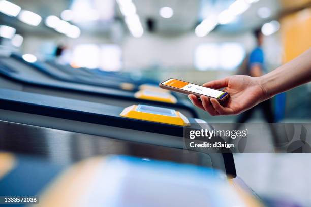 cropped shot of young asian woman checking in at subway station, making a quick and easy contactless payment for subway ticket via smartphone. nfc technology, tap and go concept - ict mobiles stock-fotos und bilder