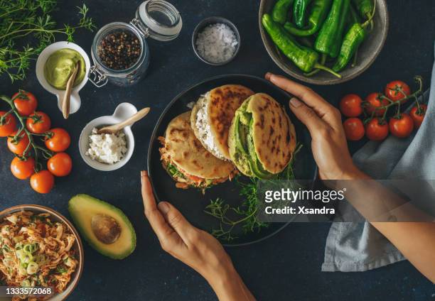 woman eating arepas - arepas stockfoto's en -beelden