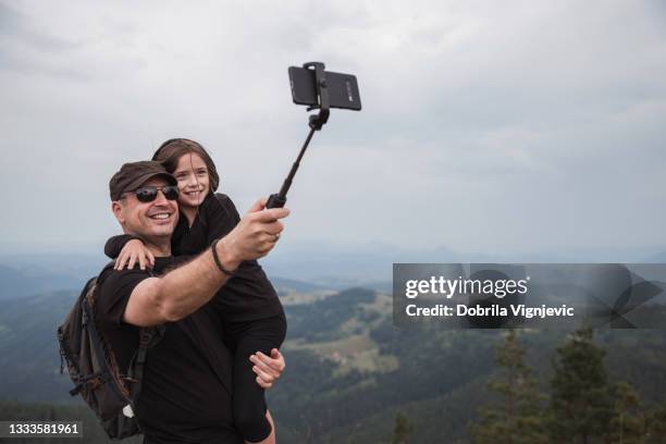 man holding daughter and taking a selfie - selfie stick stock pictures, royalty-free photos & images
