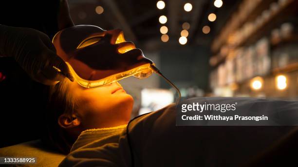 glowing cosmetology mask for phototherapy at the spa - luminothérapie photos et images de collection