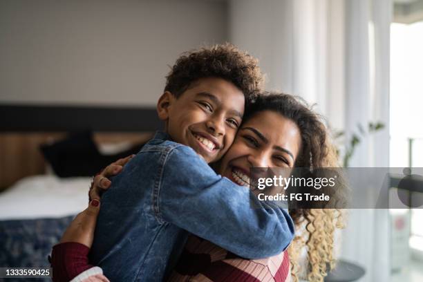 portrait of mother and son embracing at home - 一家人在家 個照片及圖片檔