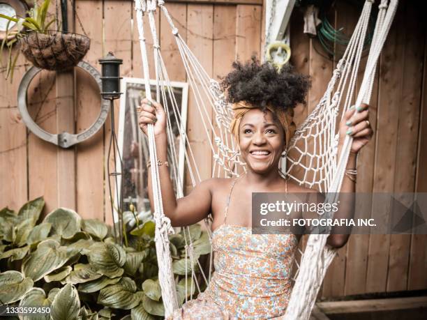 young african woman relaxing in back yard - backyard hammock stock pictures, royalty-free photos & images