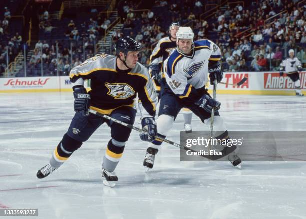 Karlis Skrastins, Defenseman for the Nashville Predators and Craig Conroy, Center for the St Louis Blues challenge for the puck during their NHL Pre...