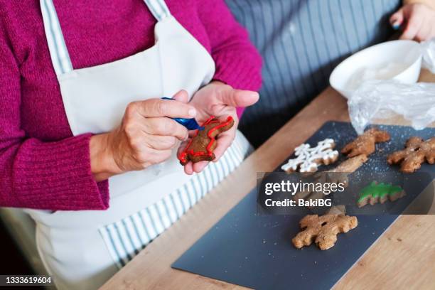 mother and daughter making christmas cookies - decorating cookies stock pictures, royalty-free photos & images