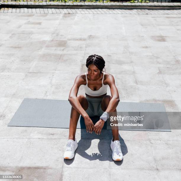 street workout: junge afroamerikanerin ruht sich nach dem training aus - long legs women stock-fotos und bilder