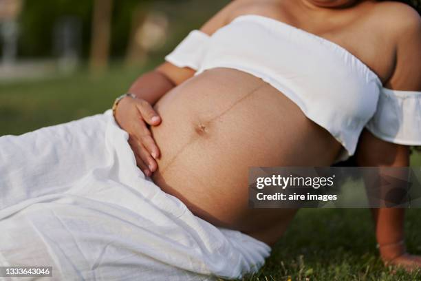 bumpy pregnant girl midsection mom maternity abdomen hands - bumpy stock pictures, royalty-free photos & images