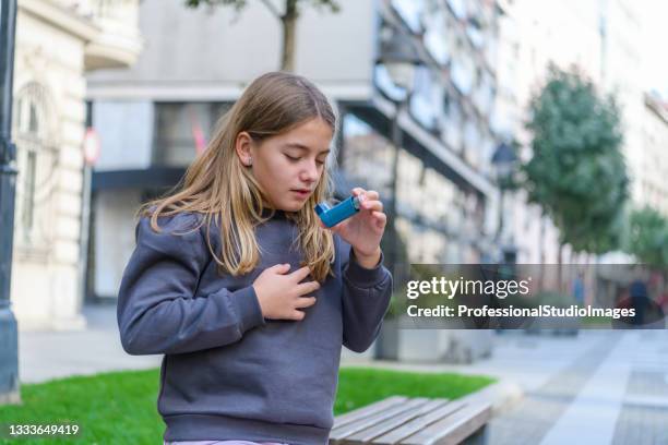 asthmatic little girl is using a smoke inhaler in a park. - asthma stock pictures, royalty-free photos & images