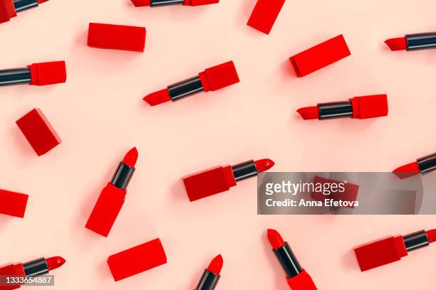 set of various bright red lipsticks on pastel yellow background. flat lay style - lipstick imagens e fotografias de stock