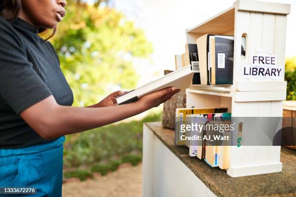 girl choosing a book from little free street library - exchanging books stock pictures, royalty-free photos & images