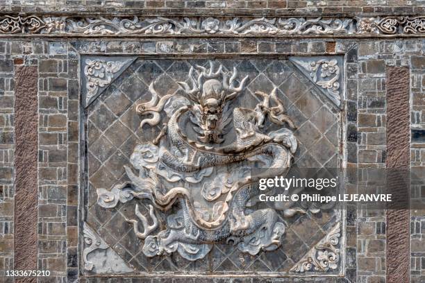 bas relief of a dragon on a wall - dragon bas relief photos et images de collection