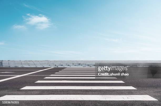 asphalt road against cloud sky - zebra crossing stock pictures, royalty-free photos & images