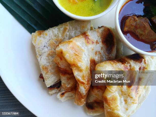 flatbread or roti canai with curry on white plate - roti canai stock pictures, royalty-free photos & images