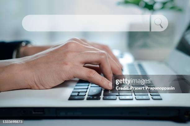 hand typing on laptop keyboard for searching information in search engine toolbox - search engine 個照片及圖片檔