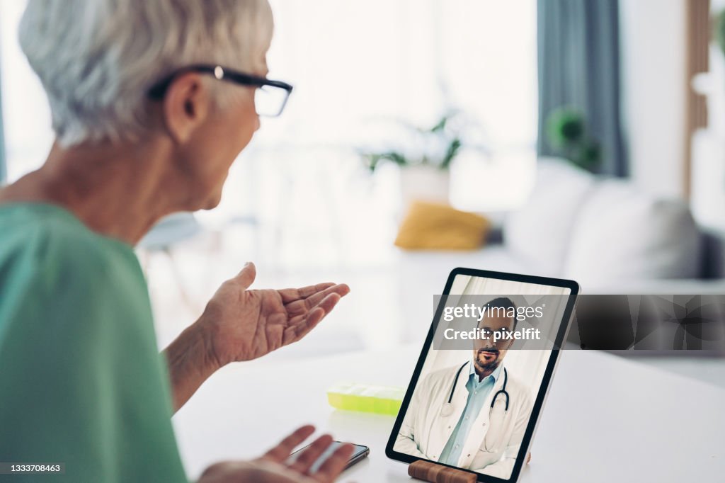 Senior woman talks to her doctor through a video call