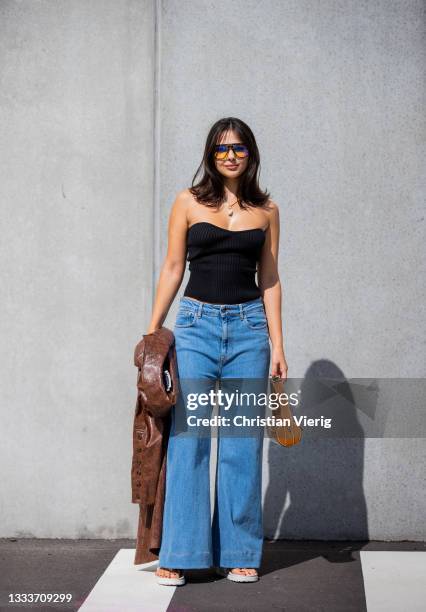 Doina Ciobanu seen wearing black off shoulder top, denim jeans outside Designers Remix on August 11, 2021 in Copenhagen, Denmark.