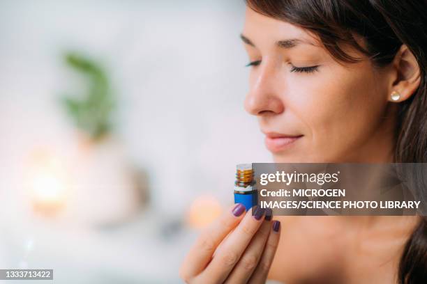 holding and smelling ayurvedic oil - aromaterapia foto e immagini stock