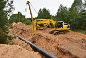 Natural Gas Pipeline Construction. Laying oil pipe in a trench in the ground. Petrochemical industry concept. Refining crude oil
