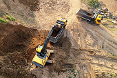 Excavator load the sand into dump truck. Aerial view of an backhoe on earthworks.