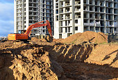 Excavator digging foundation at construction site. Heavy machinery for groungwork. House Construction Project Working.