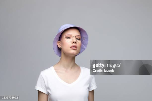 confident young woman with lilac bucket hat - purple hat stock pictures, royalty-free photos & images