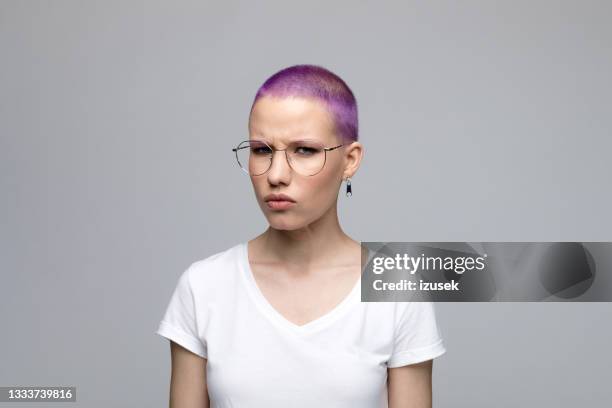 displeased young woman with short purple hair - angry women stock pictures, royalty-free photos & images