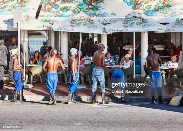 gumboot dancers about to entertain diners at sidewalk cafe in camps bay, cape town, south africa - camps bay imagens e fotografias de stock