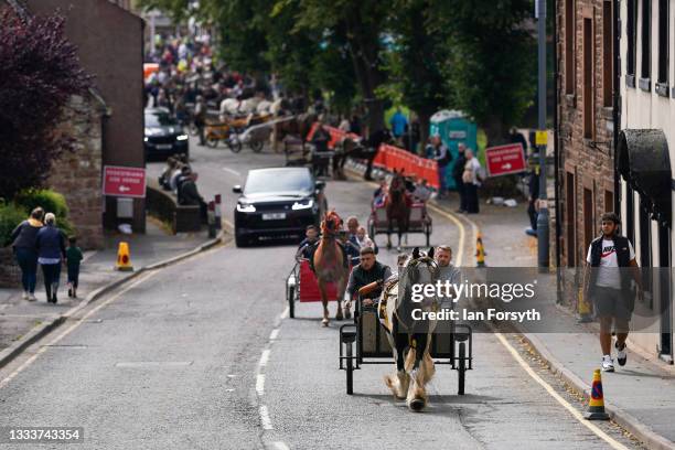 Horses and traps are driven through the town on the first day of Appleby Horse Fair on August 12, 2021 in Appleby, England. The fair is an annual...